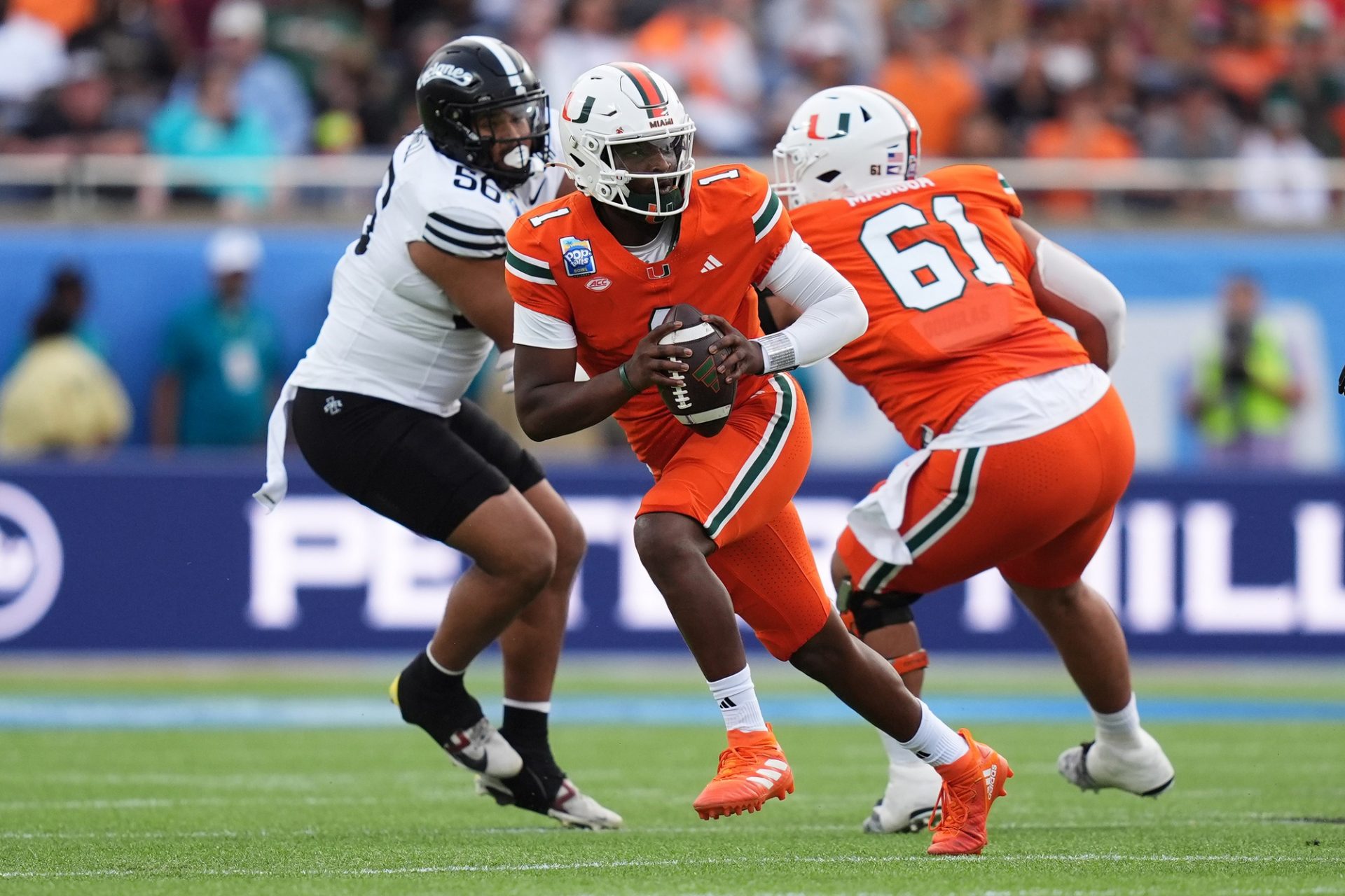 Miami Hurricanes quarterback Cam Ward (1) scrambles with the ball against the Iowa State Cyclones during the first half at Camping World Stadium.