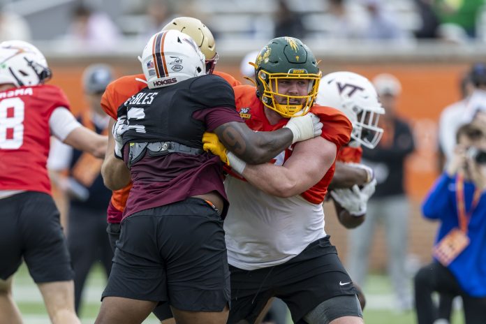 National team defensive lineman Aeneas Peebles of Virginia Tech (16) battles National team offensive lineman Grey Zabel of North Dakota State (77) during Senior Bowl practice for the National team at Hancock Whitney Stadium.