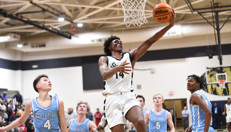 Paul Bryant guard Adrian Wooley (14) goes to the basket over several Northridge defenders in the 6A Area Final at Paul W. Bryant High School. Bryant defeated Northridge 70-59 to claim the area title.