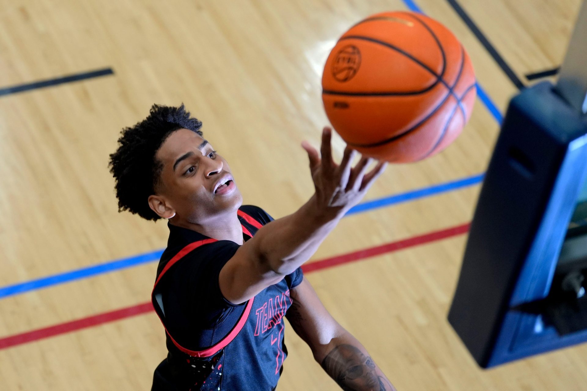 A photographer's flash goes off as Kiyan Anthony, son of NBA star Carmelo Anthony, warms up before the Team Melo and Georgia Stars game at the Nike Peach Jam at Riverview Park Activities Center. The Georgia Stars won 64-63.