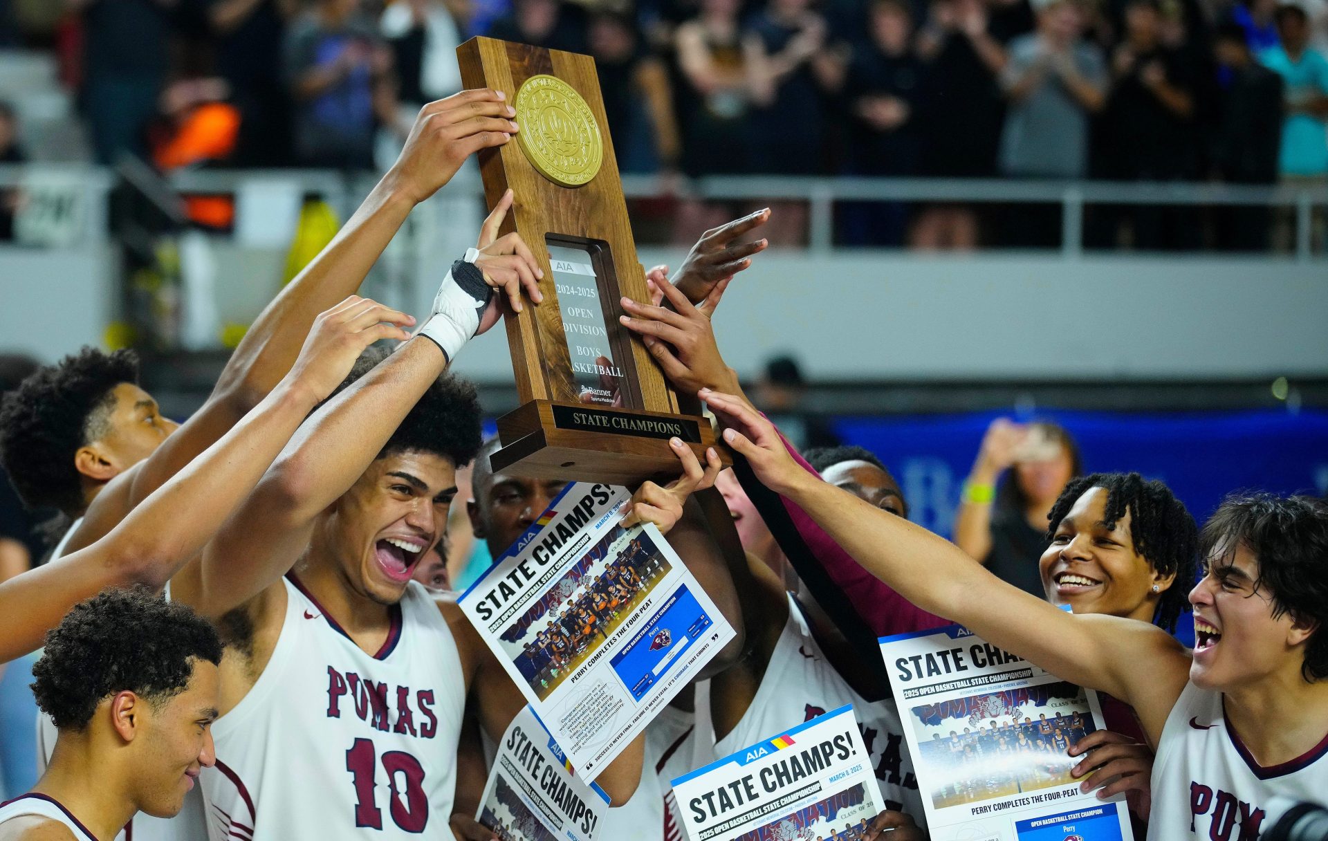 Perry forward Koa Peat holds up the trophy as he celebrates with his teammates after winning the Boys Open State Championship game over Sunnyslope at Arizona Veterans Memorial Coliseum on March 8, 2025.