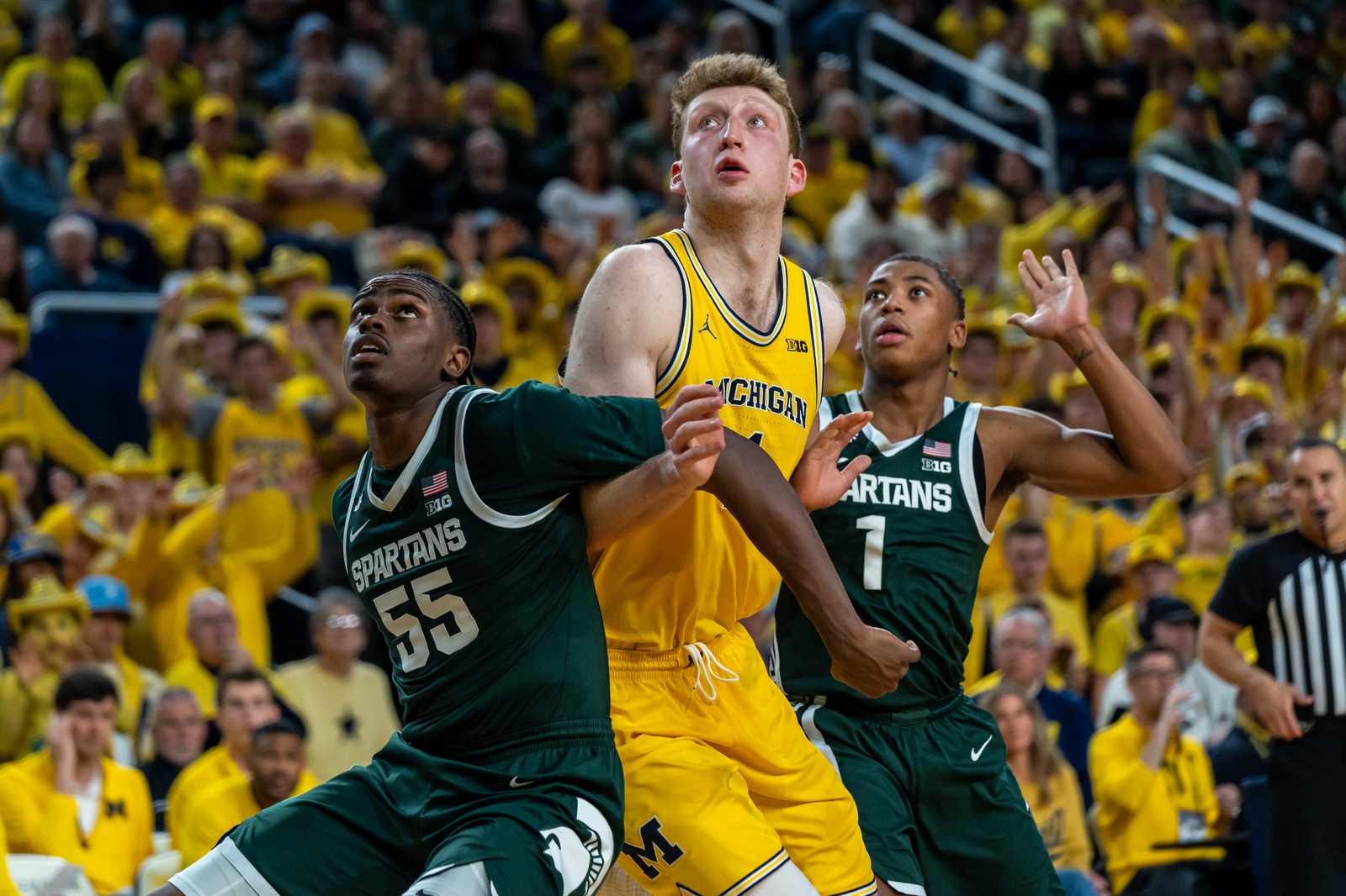 Michigan’s Danny Wolf (1) attempts to catch a rebound as Michigan State’s Coen Carr (55) and Jeremy Fears Jr. (1) box him out during the second half of their matchup at Crisler Center in Ann Arbor on Friday, Feb. 21, 2025.