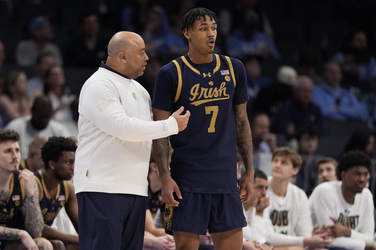 Notre Dame Fighting Irish head coach Micah Shrewsberry talks with forward Tae Davis (7) during a free throw during the second half against the North Carolina Tar Heels at Spectrum Center.