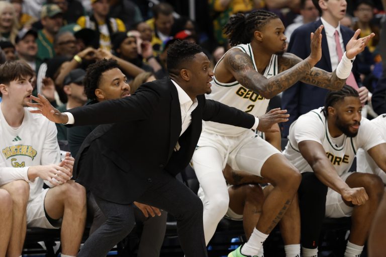 George Mason Patriots head coach Tony Skinn (L) and Patriots guard Woody Newton (2) react on the bench against the Saint Joseph's Hawks in the first half at Capital One Arena.