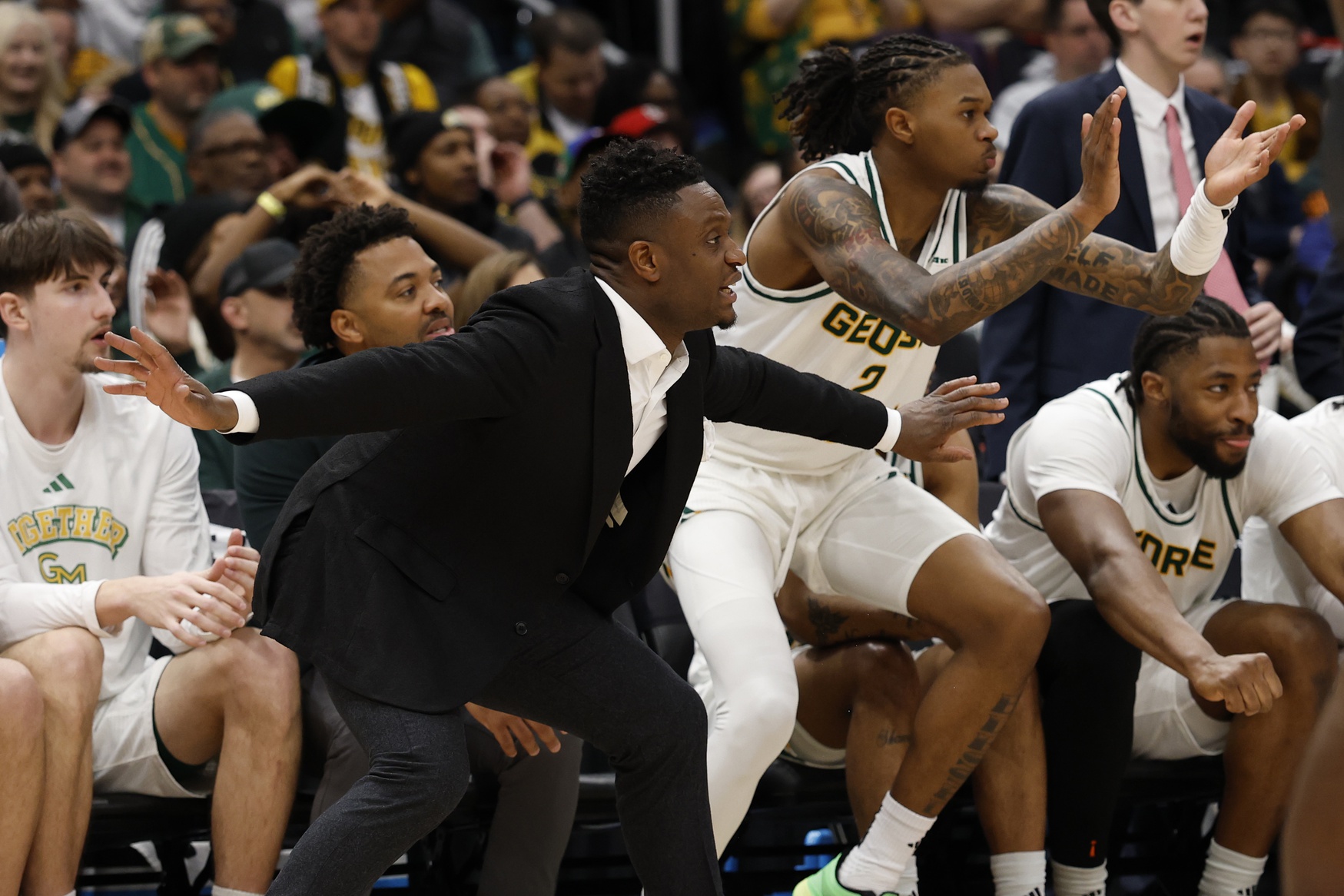 George Mason Patriots head coach Tony Skinn (L) and Patriots guard Woody Newton (2) react on the bench against the Saint Joseph's Hawks in the first half at Capital One Arena.