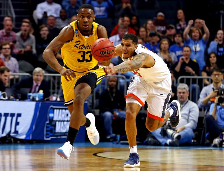 Mar 16, 2018; Charlotte, NC, USA; Virginia Cavaliers forward Isaiah Wilkins (21) fouls UMBC Retrievers forward Arkel Lamar (33) during the second half in the first round of the 2018 NCAA Tournament at Spectrum Center. Mandatory Credit: Jeremy Brevard-USA TODAY Sports
