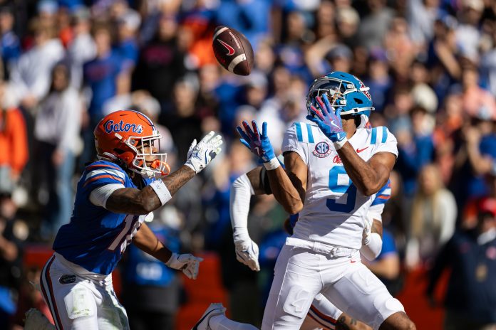 Mississippi Rebels wide receiver Tre Harris (9) makes a catch for a touchdown over Florida Gators defensive back Bryce Thornton (18) during the first half at Ben Hill Griffin Stadium.