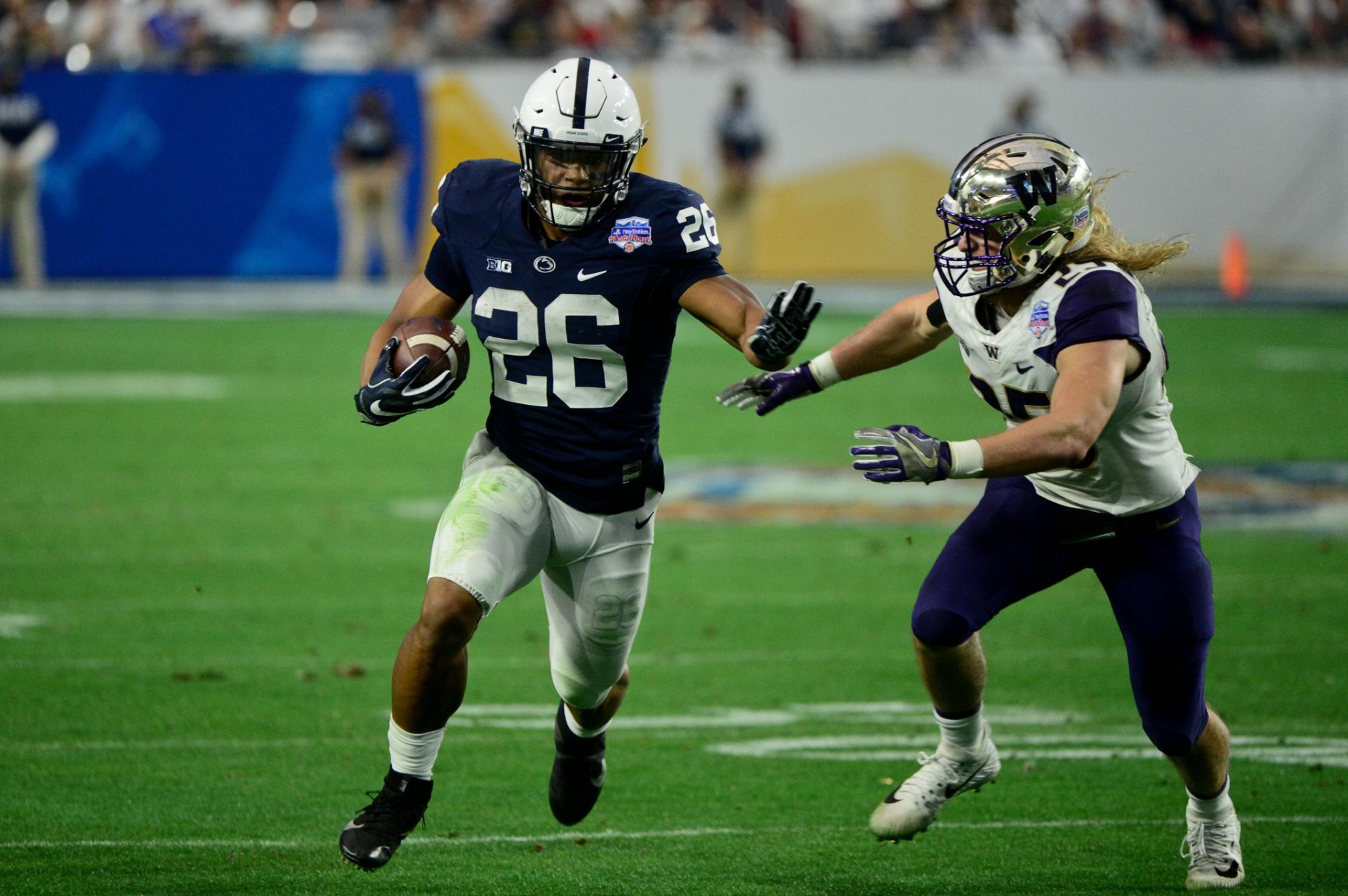 Penn State Nittany Lions running back Saquon Barkley (26) runs the ball as Washington Huskies linebacker Ben Burr-Kirven (25) defends during the second half during the 2017 Fiesta Bowl at University of Phoenix Stadium.