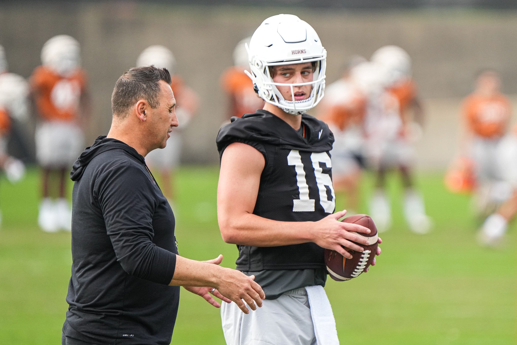 Texas head coach Steve Sarkisian talks to quarterback Arch Manning (16) during the first Texas Longhorns football practice of 2023 at the Frank Denius Fields on the University of Texas at Austin campus on Monday, March 6, 2023.