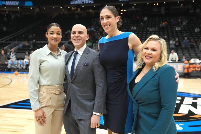ESPN sideline analyst Andraya Carter, play-by-play commentator Ryan Ruocco, analyst Rebecca Lobo and reporter Holly Rowe, pose at Climate Pledge Arena.