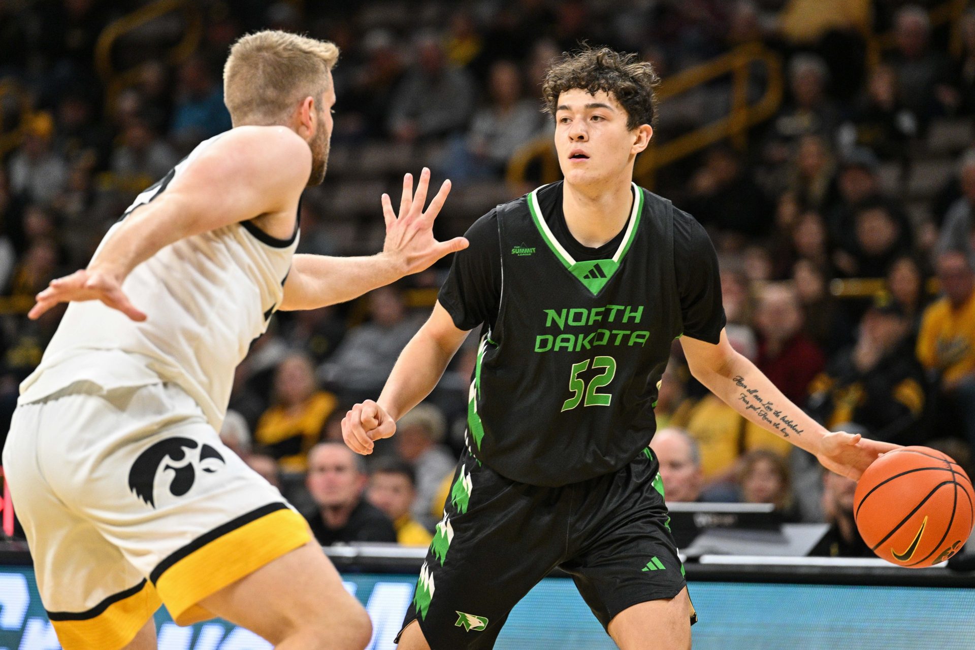 North Dakota Fighting Hawks guard Treysen Eaglestaff (52) dribbles against Iowa Hawkeyes forward Ben Krikke (23) during the first half at Carver-Hawkeye Arena.