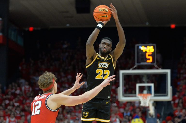 Virginia Commonwealth Rams guard Joe Bamisile (22) shoots the ball against Dayton Flyers forward Petras Padegimas (12) during the first half of the game at University of Dayton Arena.