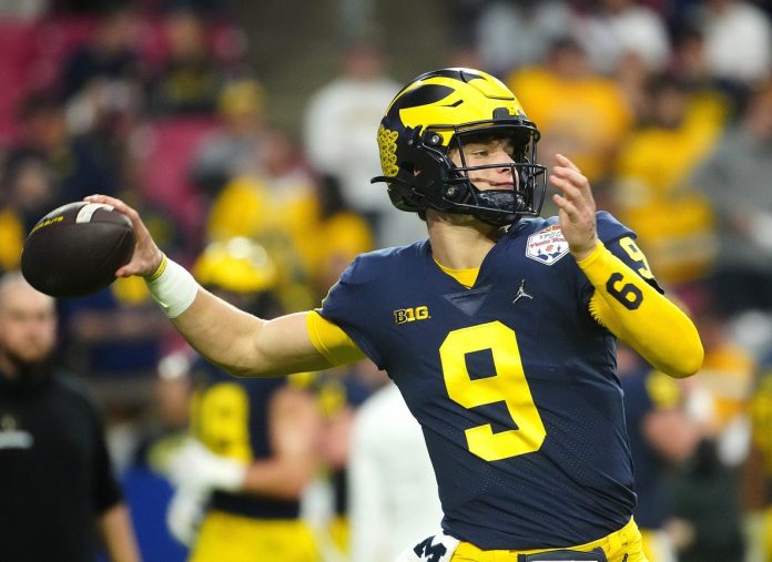 Michigan quarterback J.J. McCarthy (9) throws a pass during the pregame before the Fiesta Bowl at State Farm Stadium.