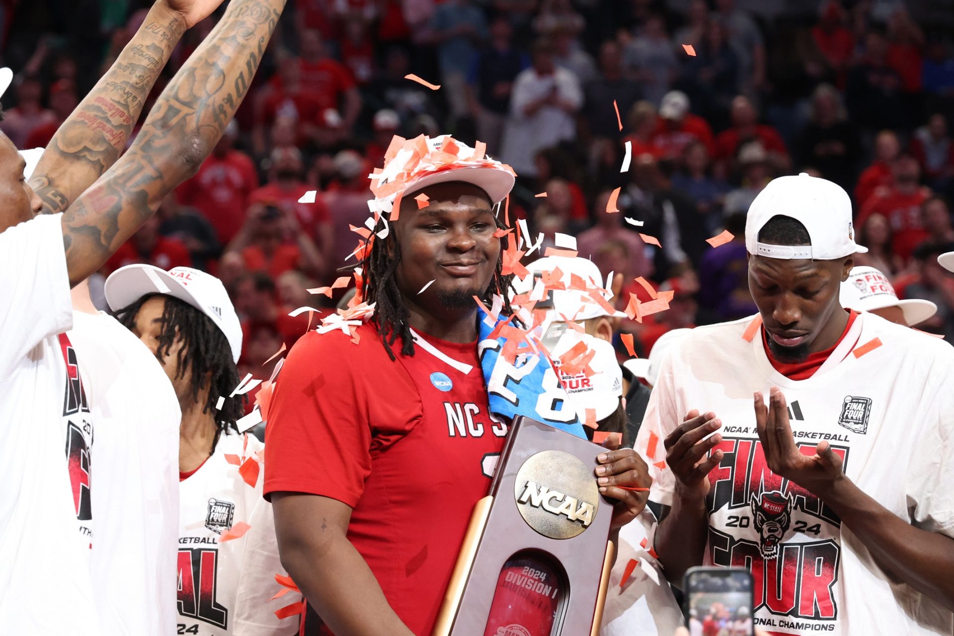 North Carolina State Wolfpack forward DJ Burns Jr. (30) celebrates with the trophy after defeating the Duke Blue Devils in the finals of the South Regional of the 2024 NCAA Tournament at American Airline Center.