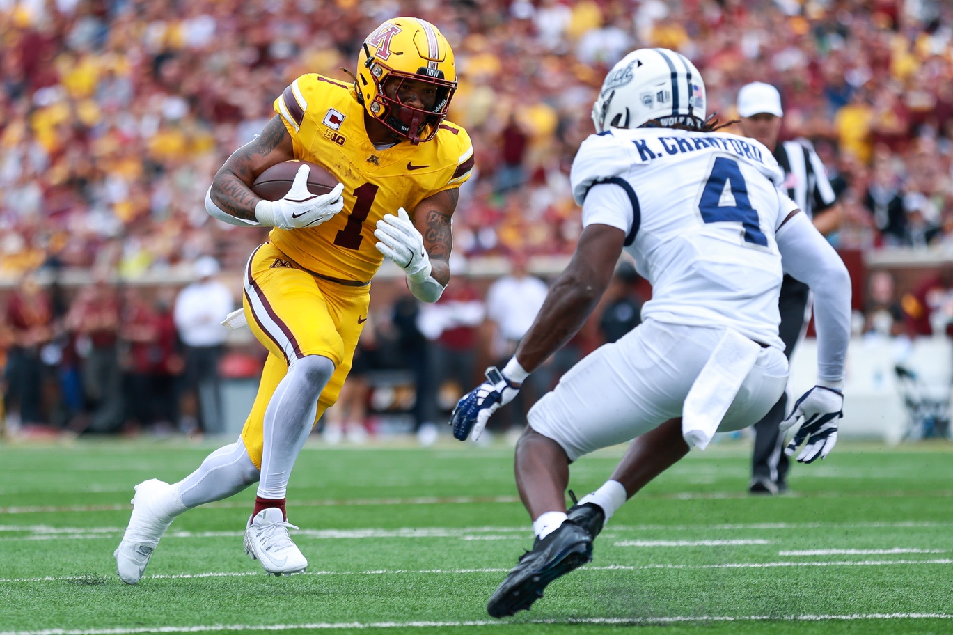 Minnesota Golden Gophers running back Darius Taylor (1) runs the ball as Nevada Wolf Pack safety Kitan Crawford (4) defends during the first half at Huntington Bank Stadium.