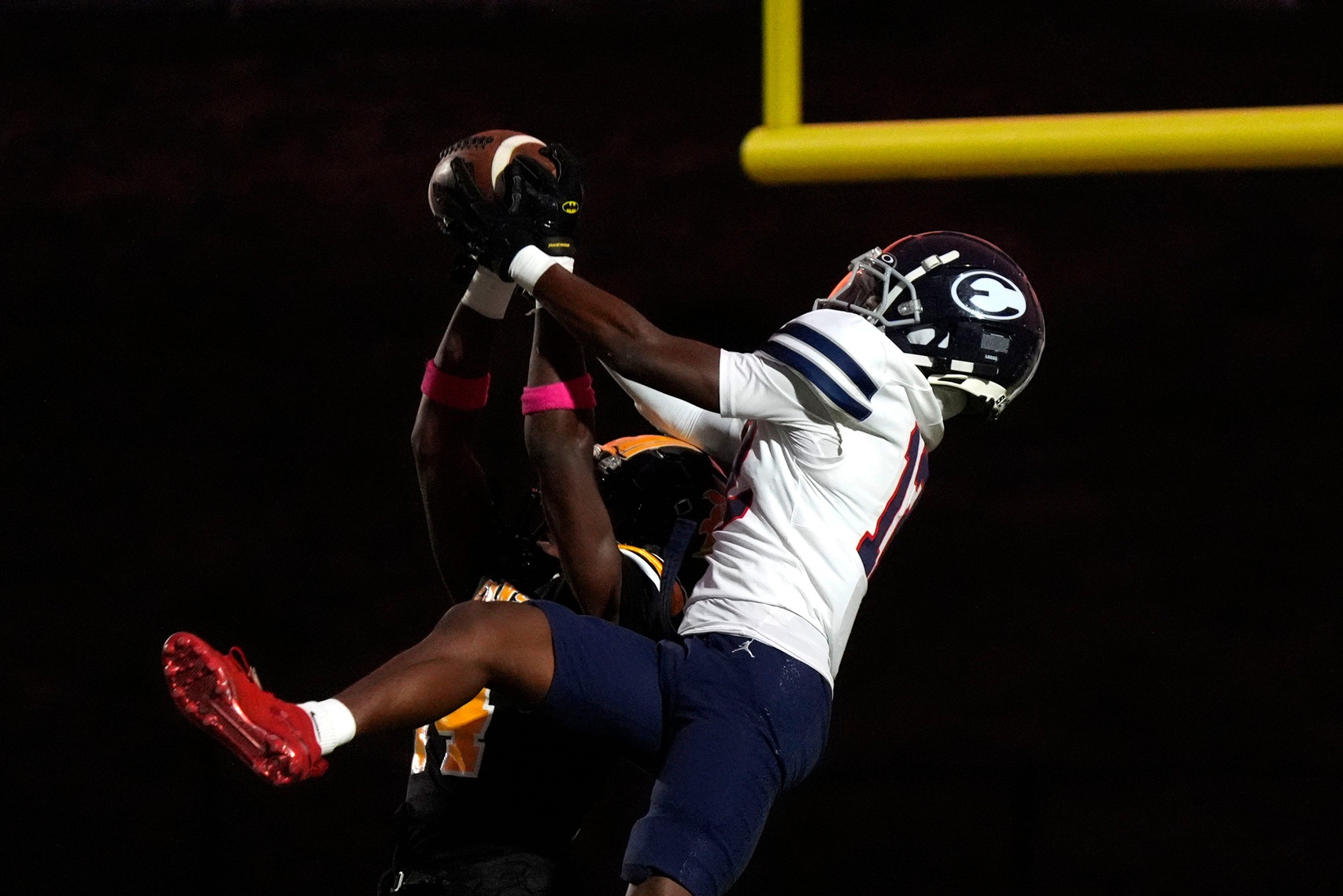 Evans cornerback Christian Scott (14) and Effingham wide receiver Trayvis Hunter (12) jump for the ball during the Evans and Effingham County football game at Evans High School on Wednesday, Oct. 9, 2024. This week marks the return of high school football after Hurricane Helene. Effingham County defeated Evans with a score of 35-7.