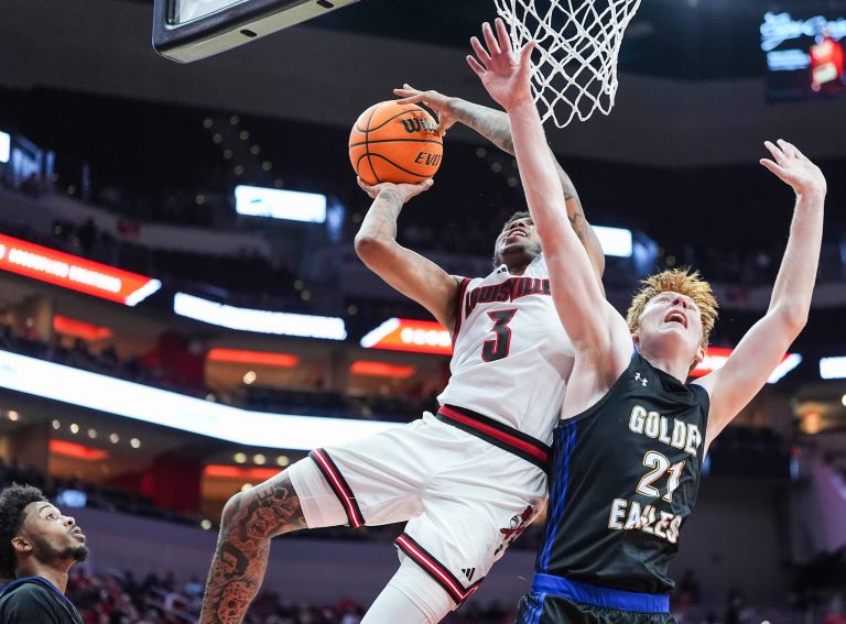 Louisville Cardinals guard Koren Johnson (3) gets two plus the foul against Spalding University's Levi Langley (21) in the second half