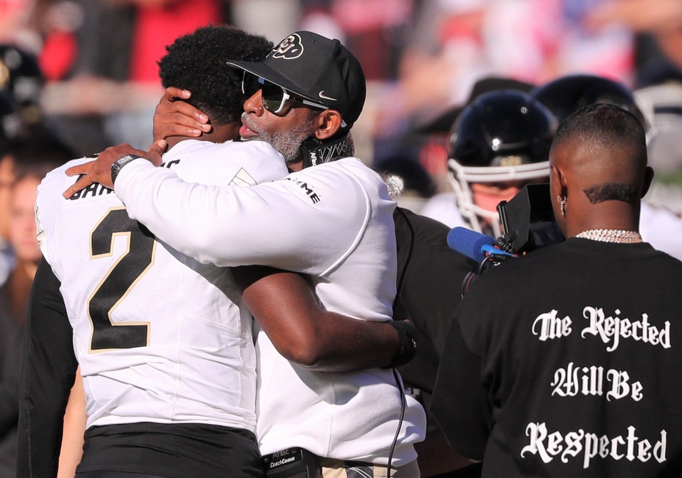 Colorado football coach Deion Sanders hugs his son, Shedeur Sanders, before facing Texas Tech.