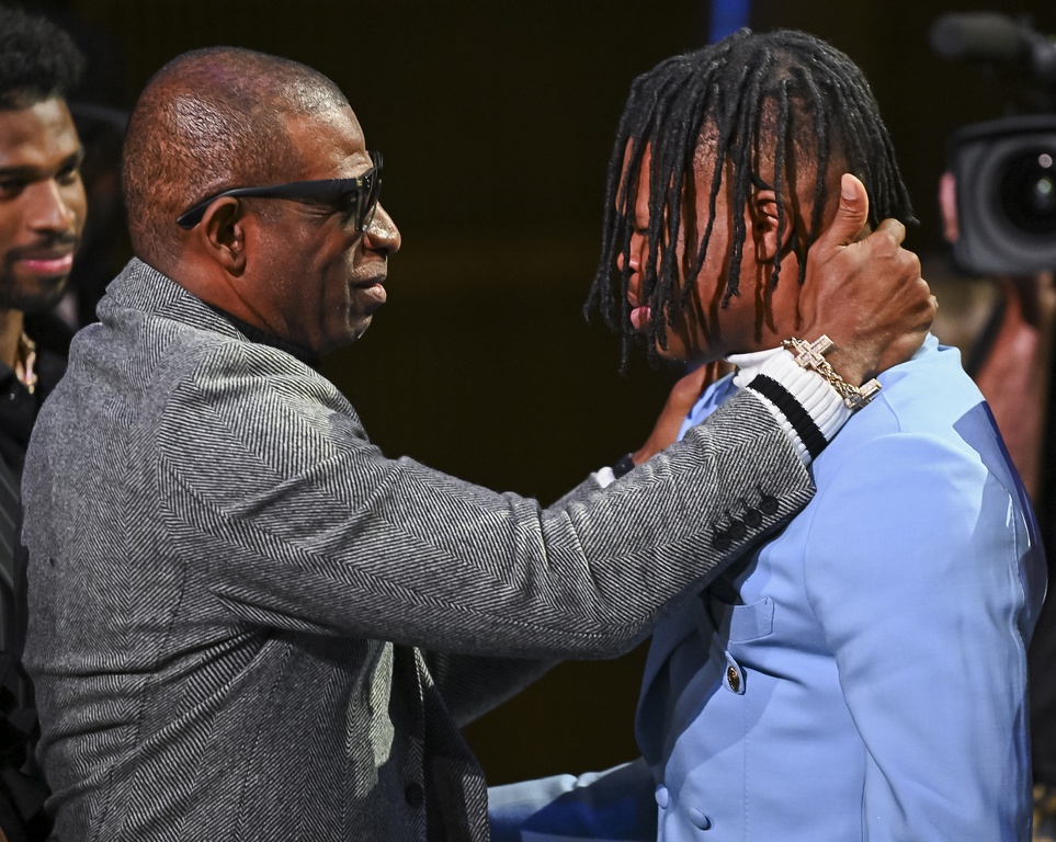 Colorado Buffaloes wide receiver/cornerback Travis Hunter with head coach Deion Sanders after winning the 2024 Heisman Trophy.