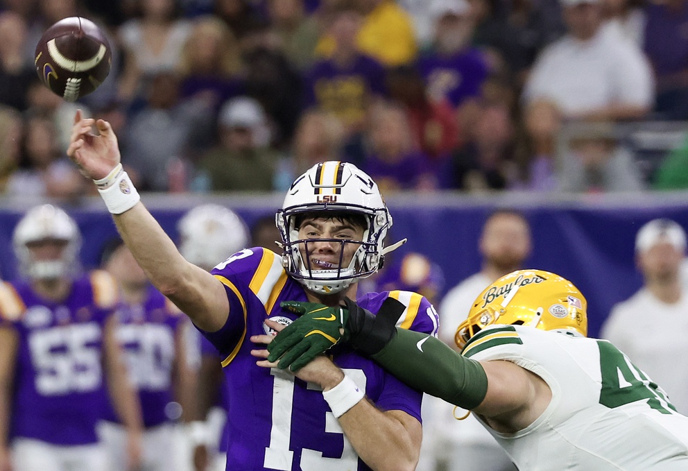 LSU Tigers quarterback Garrett Nussmeier (13) is hit by Baylor Bears linebacker Josh White (44) in the second half at NRG Stadium.