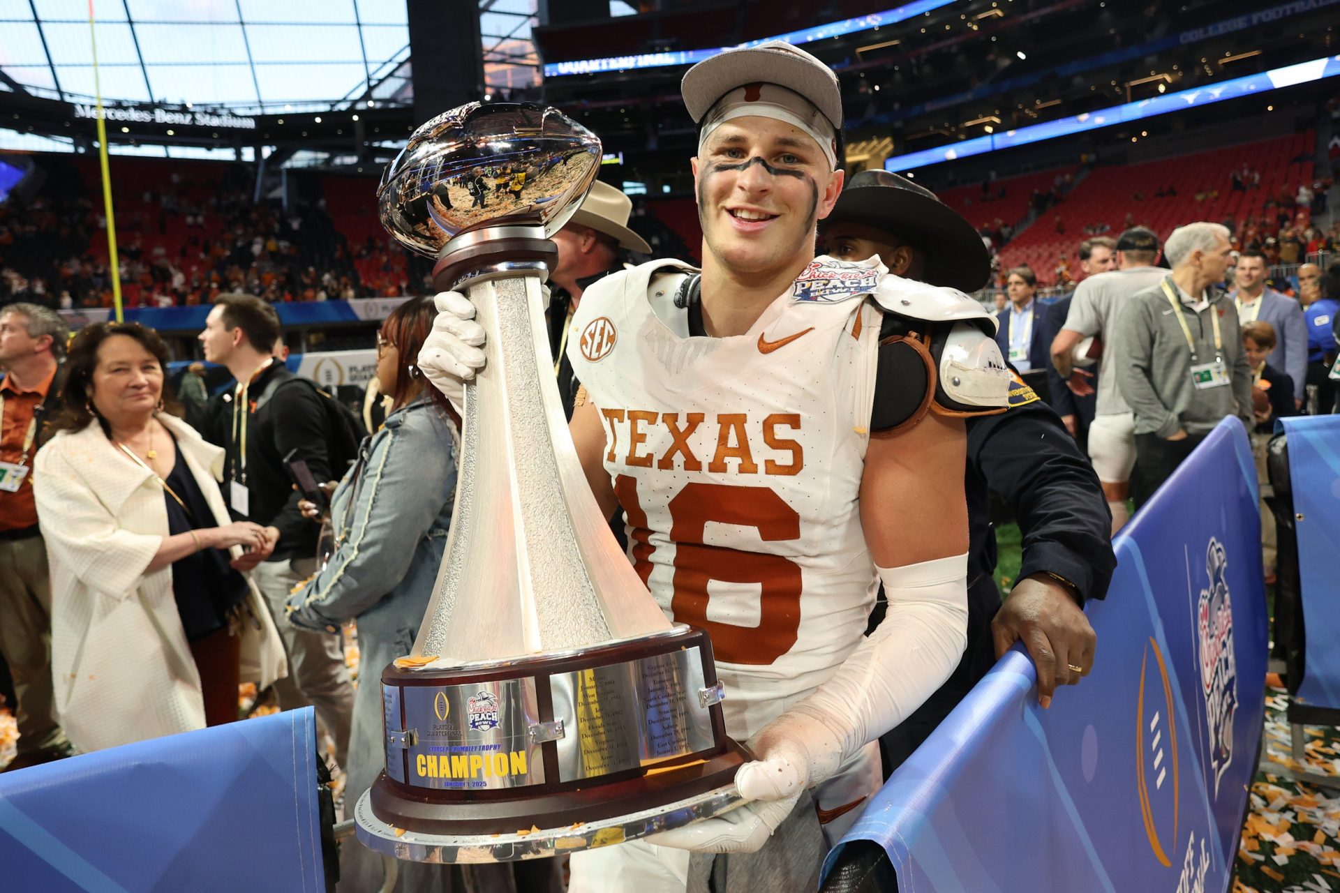 Texas Longhorns defensive back Michael Taaffe (16) poses with the trophy after a victory over the Arizona State Sun Devils in the Peach Bowl at Mercedes-Benz Stadium.