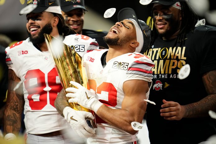 running back TreVeyon Henderson (32) celebrates with the trophy