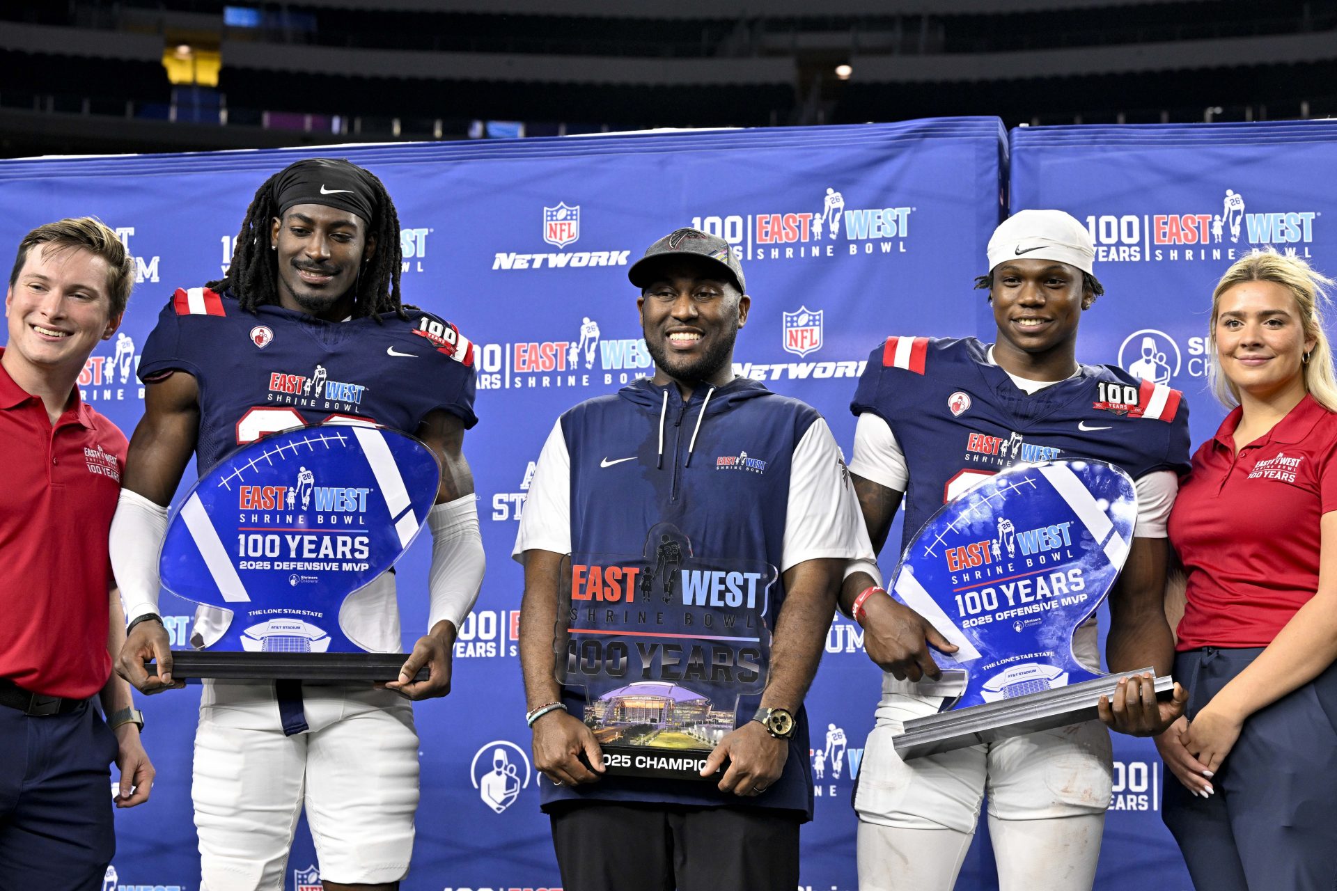 (from left) East defensive back O'Donnell Fortune of South Carolina (20) and East head coach Marquice Williams of the Atlanta Falcons and East running back Jacory Croskey-Merritt of Arizona (31) pose with MVP trophies and game trophy after the East defeats the West in the East-West Shrine Bowl at AT&T Stadium.