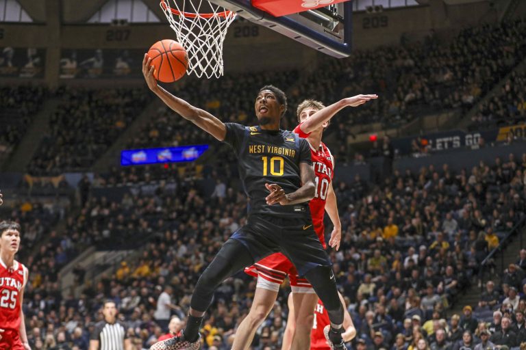 West Virginia Mountaineers guard Sencire Harris (10) drives past Utah Utes forward Jake Wahlin (10) and shoots during the first half at WVU Coliseum.