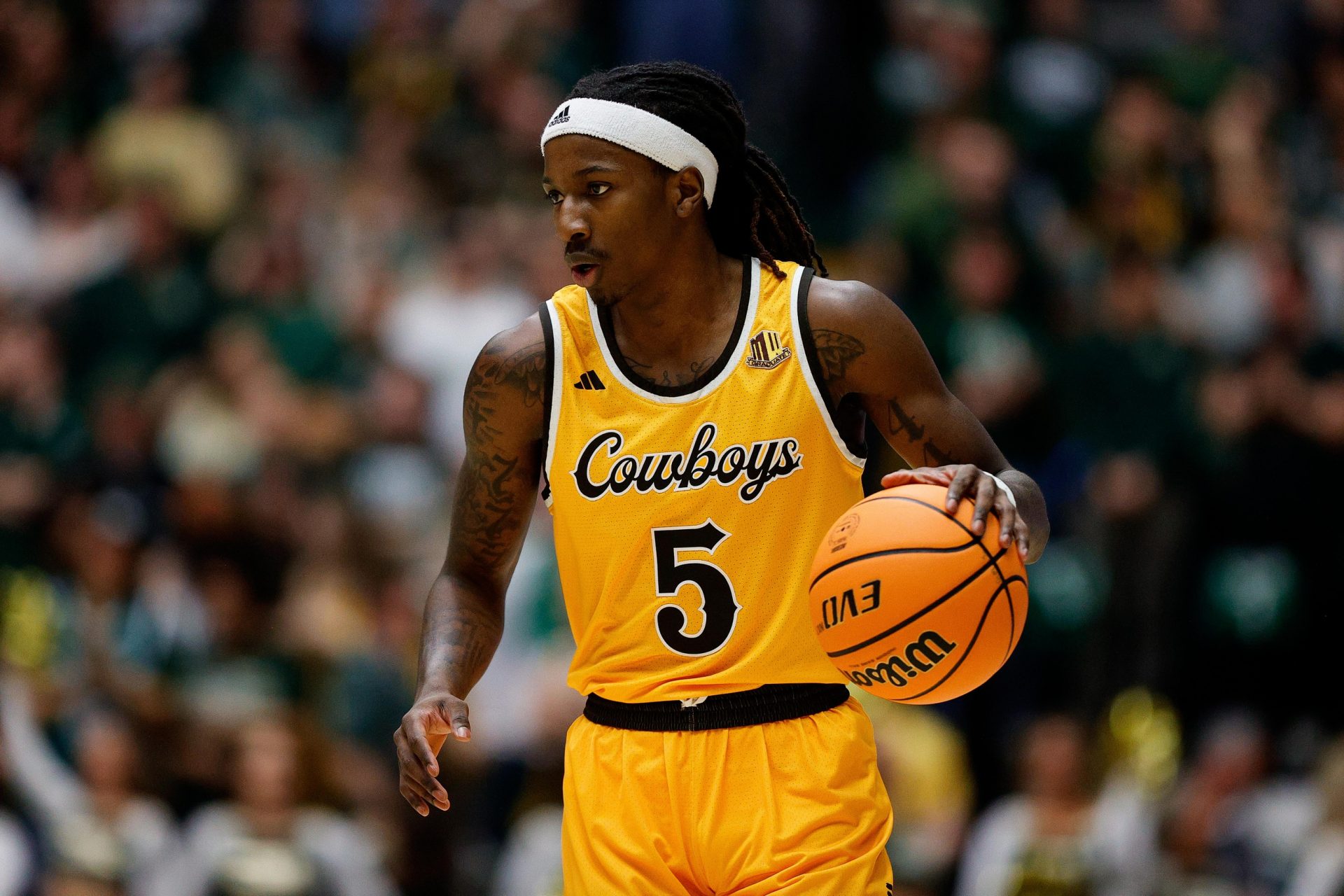 Wyoming Cowboys guard Obi Agbim (5) dribbles the ball up court in the first half against the Colorado State Rams at Moby Arena.