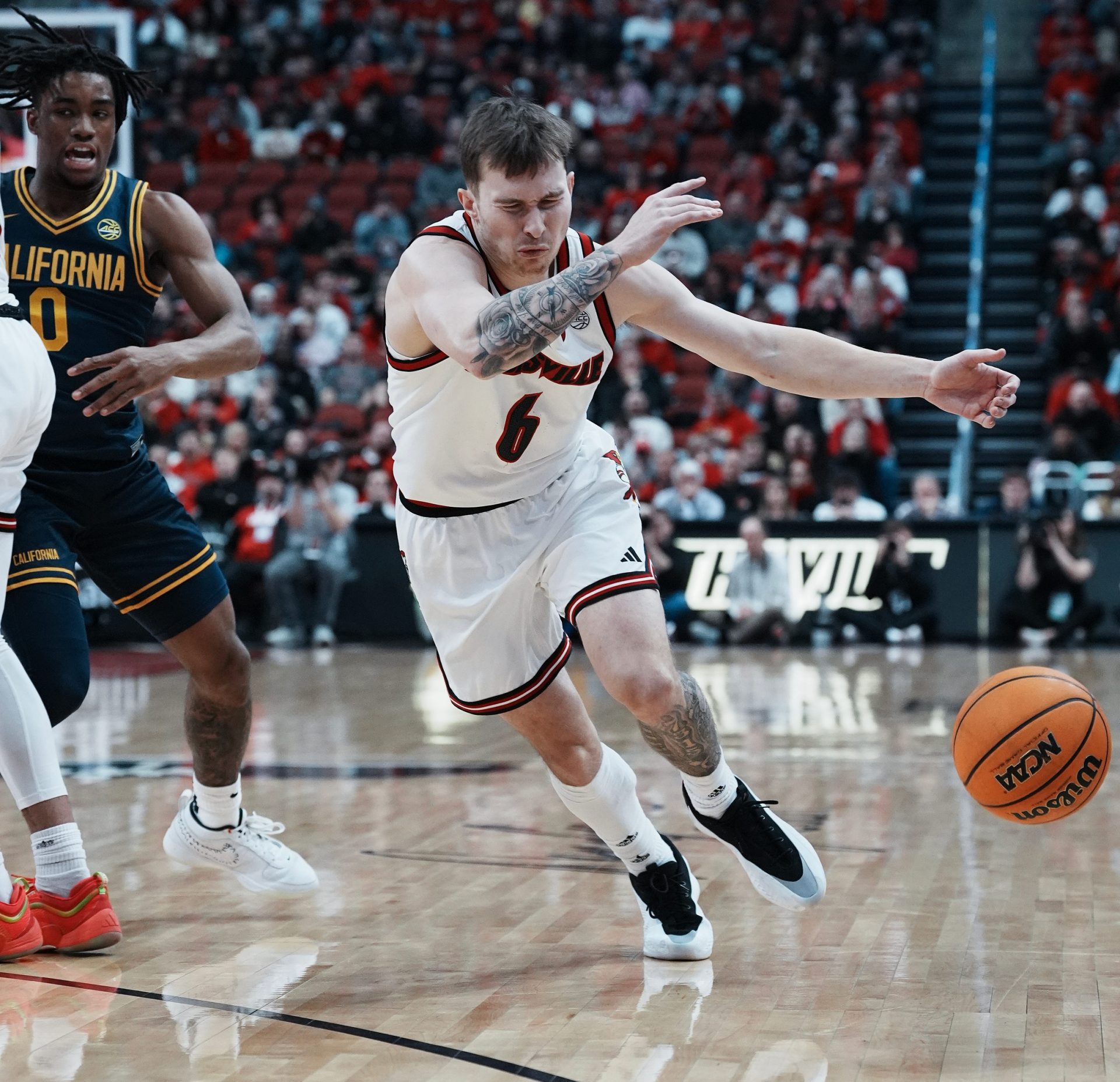 Louisville guard Reyne Smith (6) winced as he tried to control a loose ball against California during their game at the KFC Yum! Center in Louisville, Ky. on Mar. 5, 2025. Smith had to leave the game later with an injury on another play.