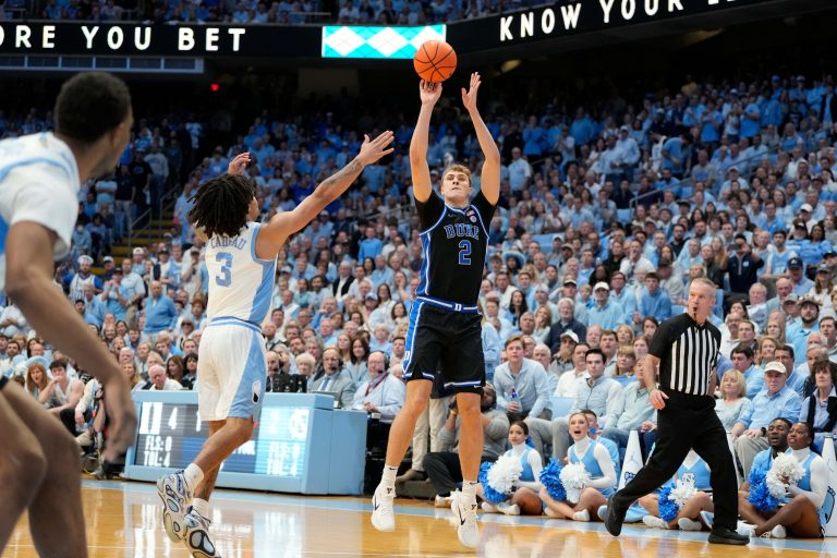 Duke Blue Devils forward Cooper Flagg (2) shoots as North Carolina Tar Heels guard Elliot Cadeau (3) defends in the first half at Dean E. Smith Center.