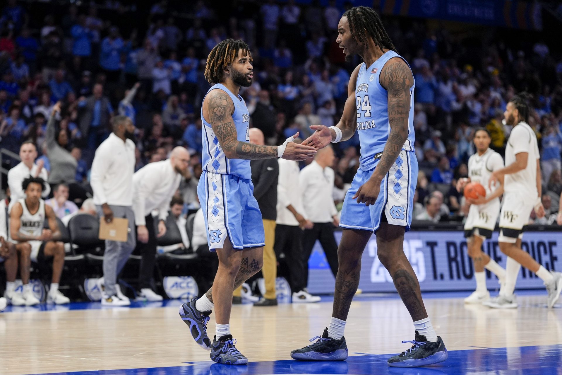 North Carolina Tar Heels guard RJ Davis (4) and forward Jae'Lyn Withers (24) congratulate each other on the victory over Wake Forest Demon Deacons during the second half at Spectrum Center.