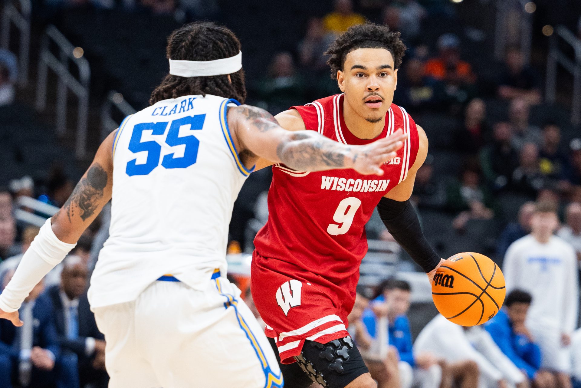 Wisconsin Badgers guard John Tonje (9) dribbles the ball while UCLA Bruins guard Skyy Clark (55) defends