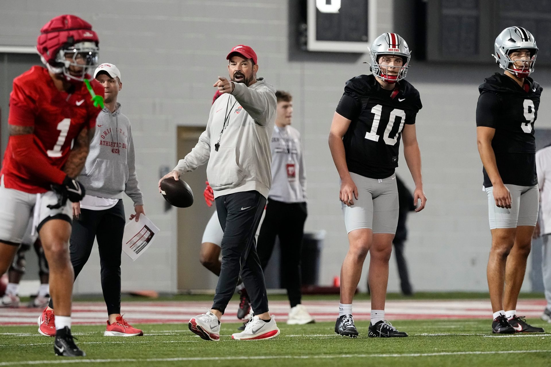 Ohio State Buckeyes head coach Ryan Day works with quarterbacks Julian Sayin (10) and Tavien St. Clair (9) during spring football practice