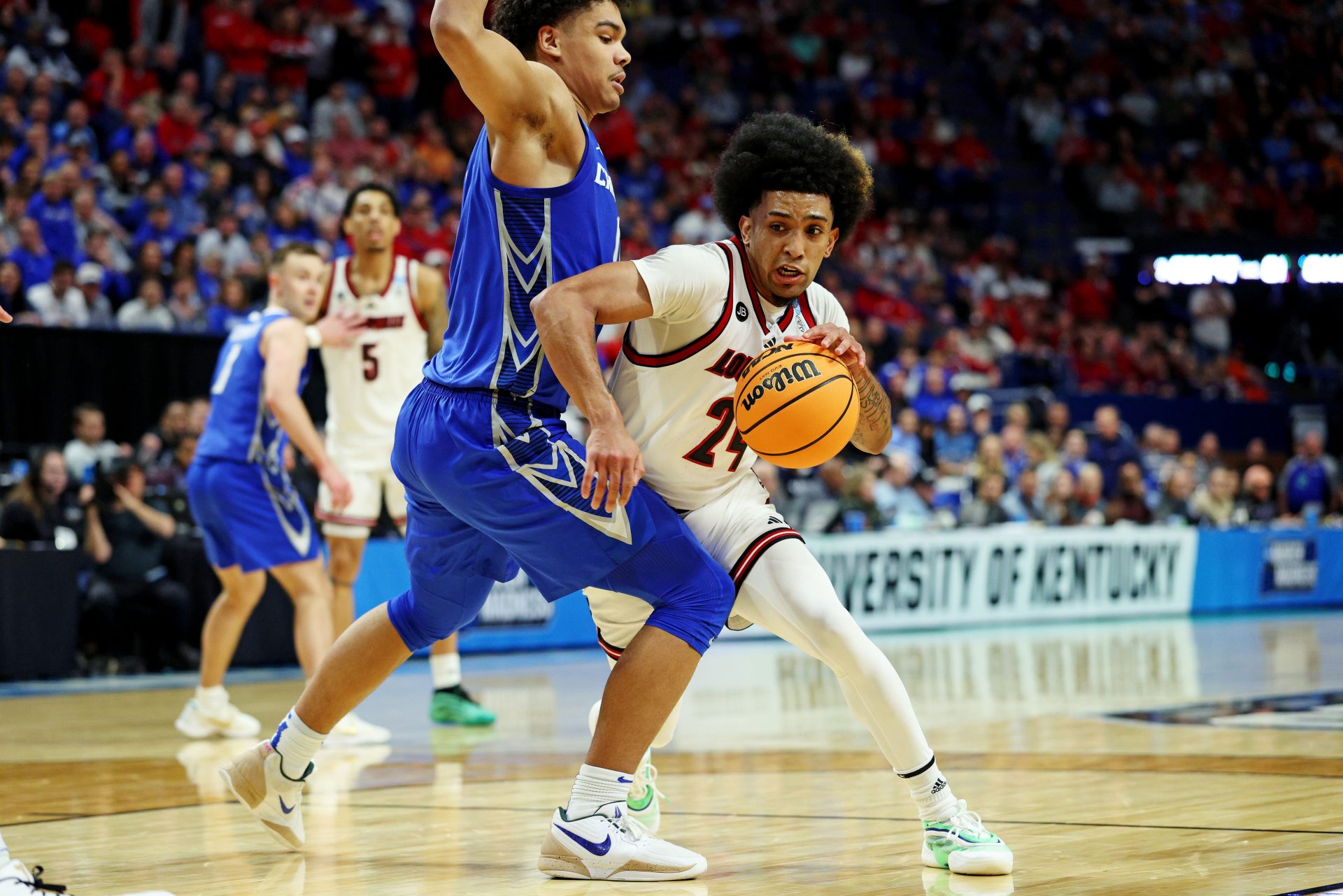 Louisville Cardinals guard Chucky Hepburn (24) drives to the basket against Creighton Bluejays forward Jasen Green (0) in the first round of the NCAA Tournament at Rupp Arena.