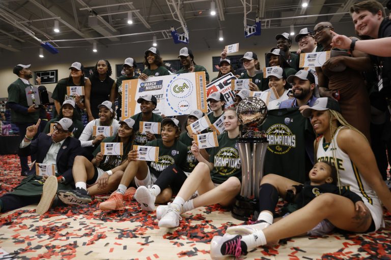 George Mason Patriots players pose for a photo with the trophy after winning the during Atlantic 10 Conference Tournament Championship game against the Saint Josephs Hawks at Henrico Sports & Events Center.