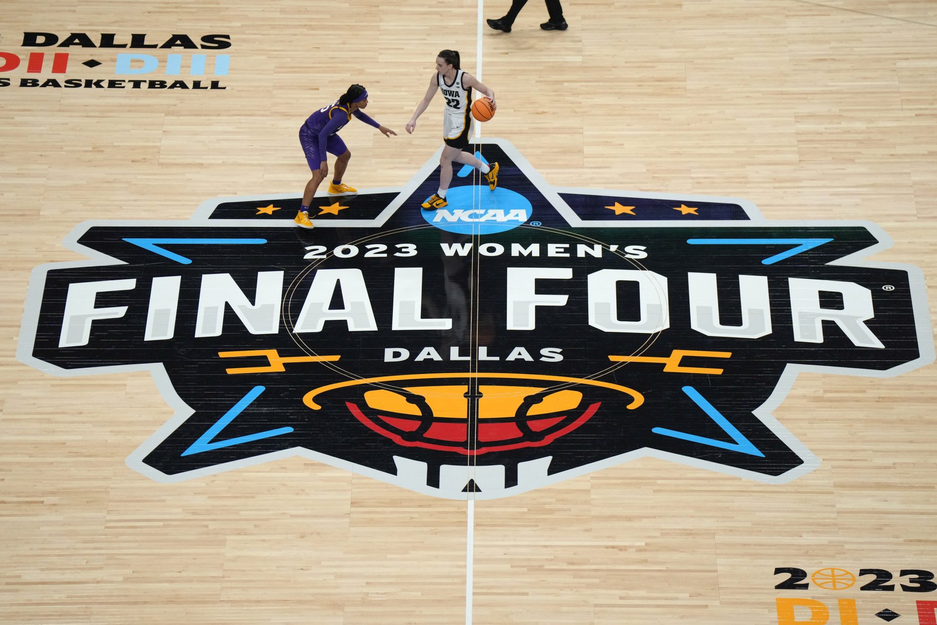 A general overall view as Iowa Hawkeyes guard Caitlin Clark (22) dribbles the ball against LSU Lady Tigers guard Alexis Morris (45) on the March Madness Final Four logo at center court during the NCAA Womens Basketball Final Four National Championship at American Airlines Center.