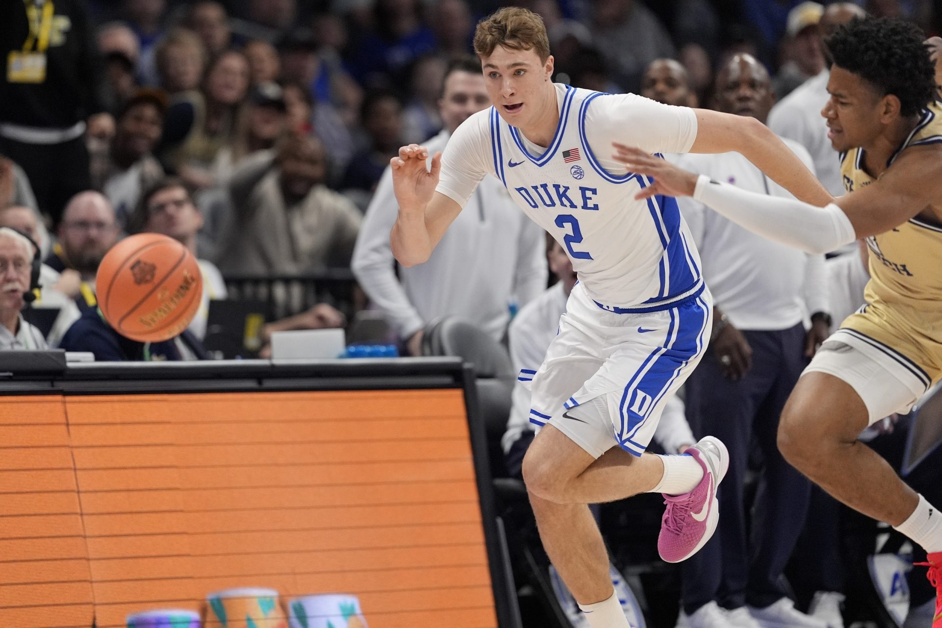 Duke Blue Devils forward Cooper Flagg (2) and Georgia Tech Yellow Jackets guard Jaeden Mustaf (3) chase the loose ball during the first half at Spectrum Center.