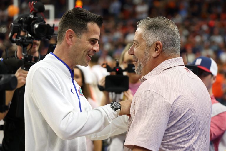 Florida Gators head coach Todd Golden talks with Auburn Tigers head coach Bruce Pearl before their game at Neville Arena.