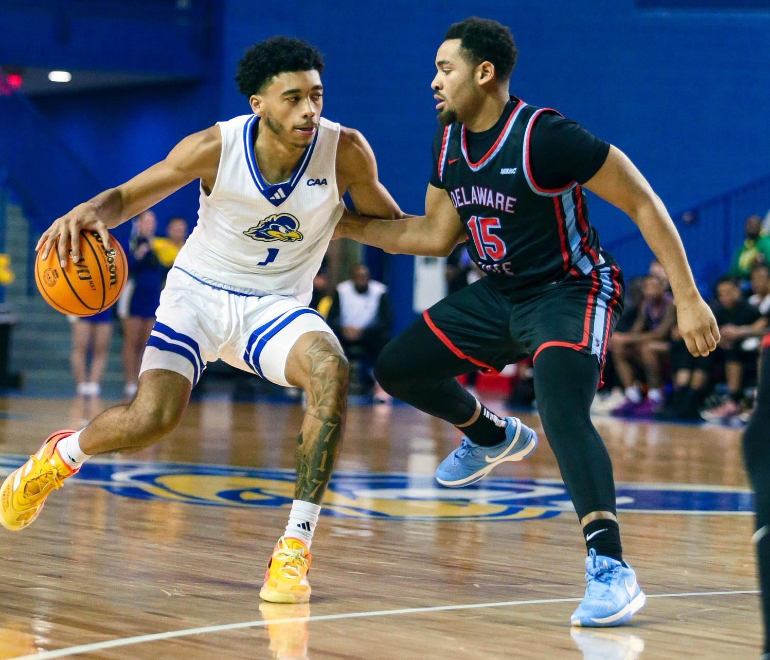 Delaware's Izaiah Pasha (left) controls the ball against Delaware State's Ponce James in the second half of the Blue Hens' 93-80 win