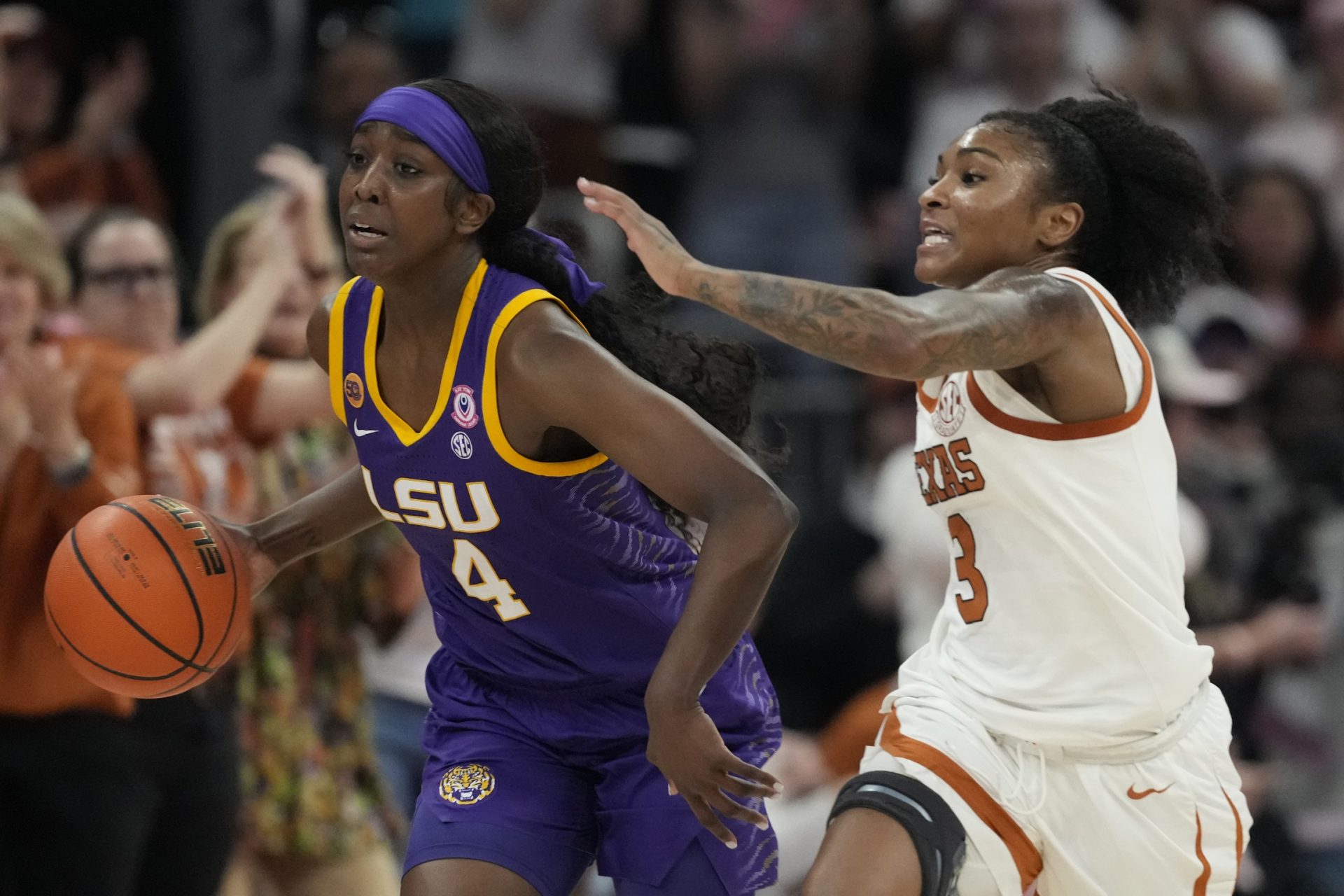 Louisiana State Lady Tigers guard Flau'jae Johnson (4) dribbles up court while defended by Texas Longhorns guard Rori Harmon (3) during the second half at Moody Center.