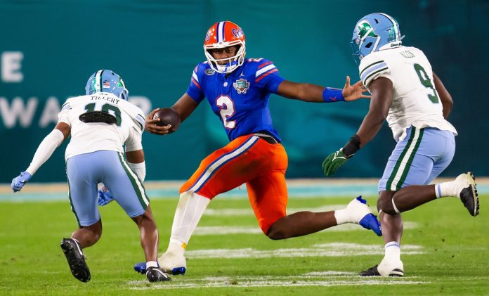 Florida Gators quarterback DJ Lagway (2) eludes Tulane Green Wave defensive back Lu Tillery (10) and Tulane Green Wave linebacker Terrell Allen (9) during the second half at Raymond James Stadium