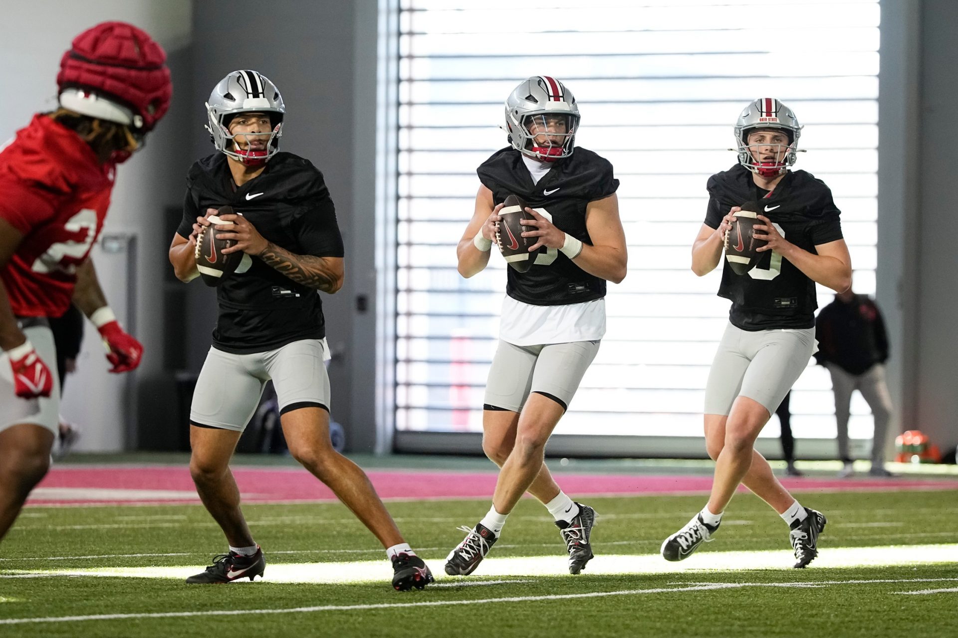 Ohio State Buckeyes quarterbacks, from right, Julian Sayin, Lincoln Kienholz and Tavien St. Clair throw during spring football practice