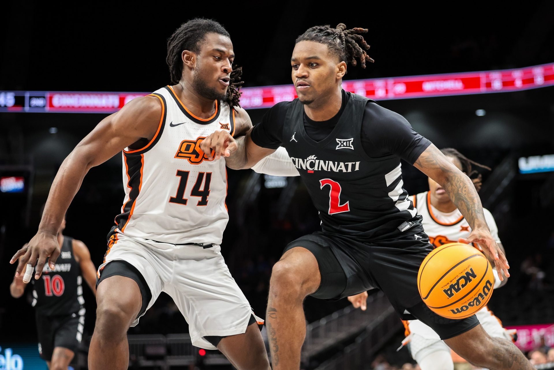 Cincinnati Bearcats guard Jizzle James (2) drives to the basket around Oklahoma State Cowboys guard Jamyron Keller (14) during the second half at T-Mobile Center.