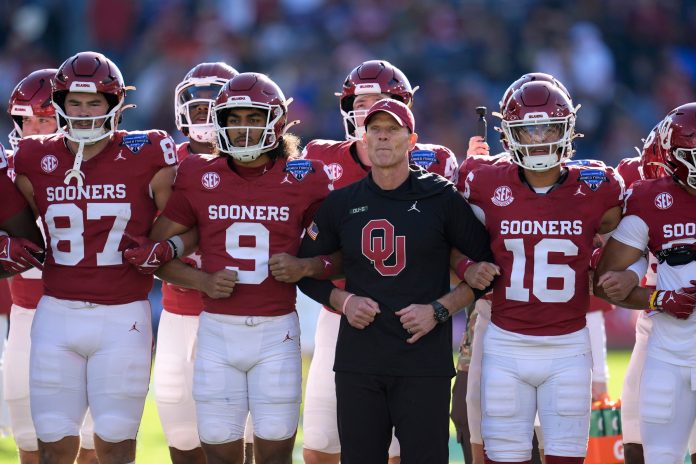 Oklahoma coach Brent Venables stands with his team before the Armed Forces Bowl football game between the University of Oklahoma Sooners (OU) and the Navy Midshipmen at Amon G. Carter Stadium