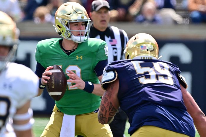 Notre Dame Fighting Irish quarterback CJ Carr (12) is pressured by defensive lineman Sean Sevillano Jr. (59) in the second half of the Blue-Gold Game at Notre Dame Stadium.