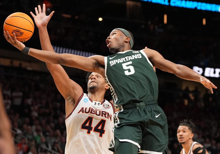 Michigan State Spartans guard Tre Holloman (5) shoots against Auburn Tigers center Dylan Cardwell (44) during the first half in the South Regional final of the 2025 NCAA tournament at State Farm Arena.