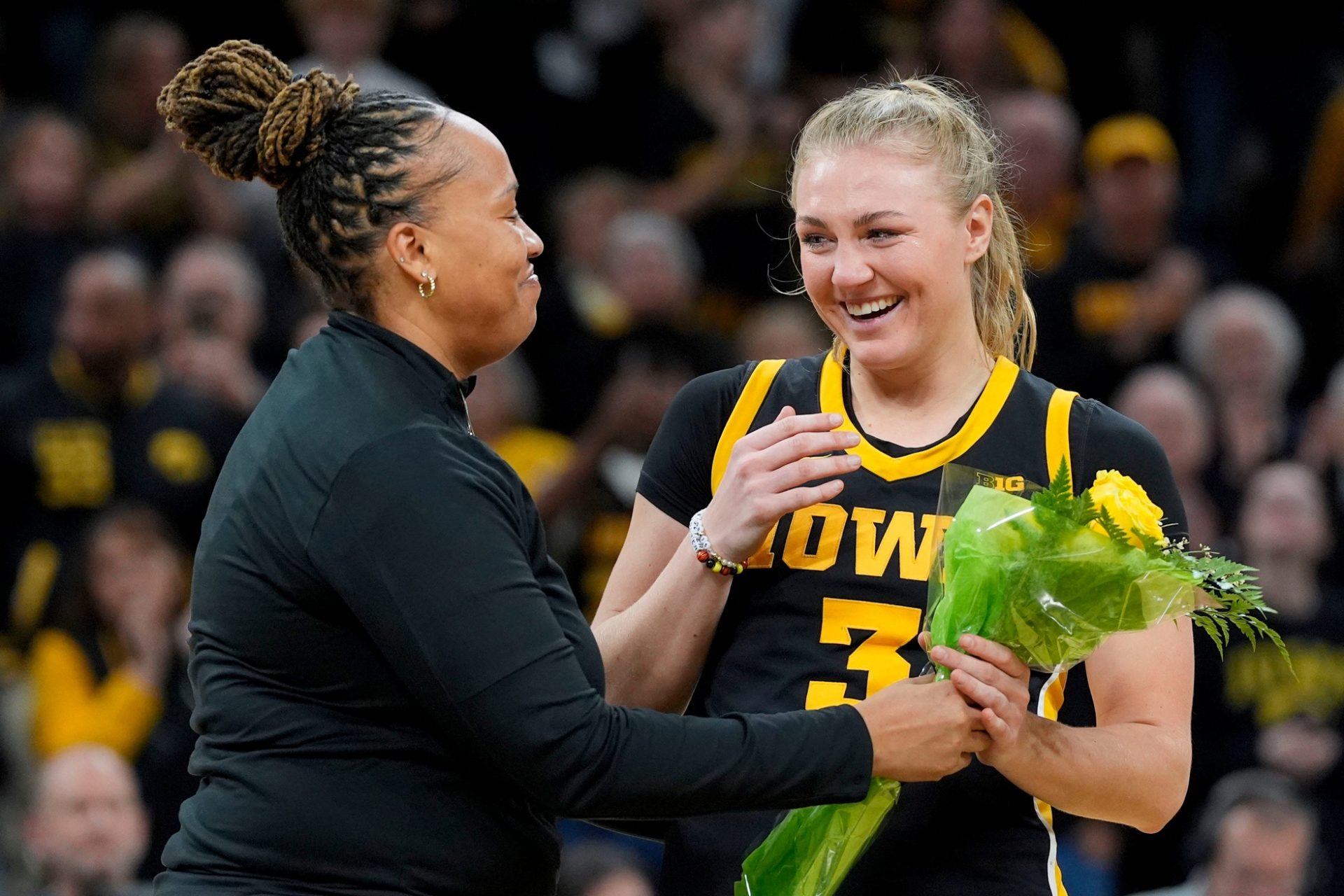 Iowa guard Sydney Affolter (3) receives flowers from assistant coach Raina Harmon during senior recognition after playing Wisconsin Sunday, March 2, 2025 at Carver-Hawkeye Arena in Iowa City, Iowa.