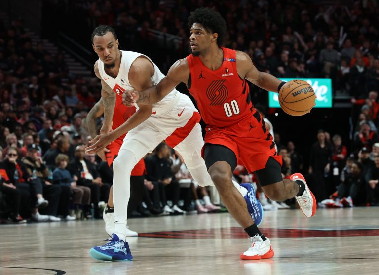Portland Trail Blazers guard Scoot Henderson (00) dribbles the ball past Toronto Raptors guard A.J. Lawson (0) in the second half at Moda Center.