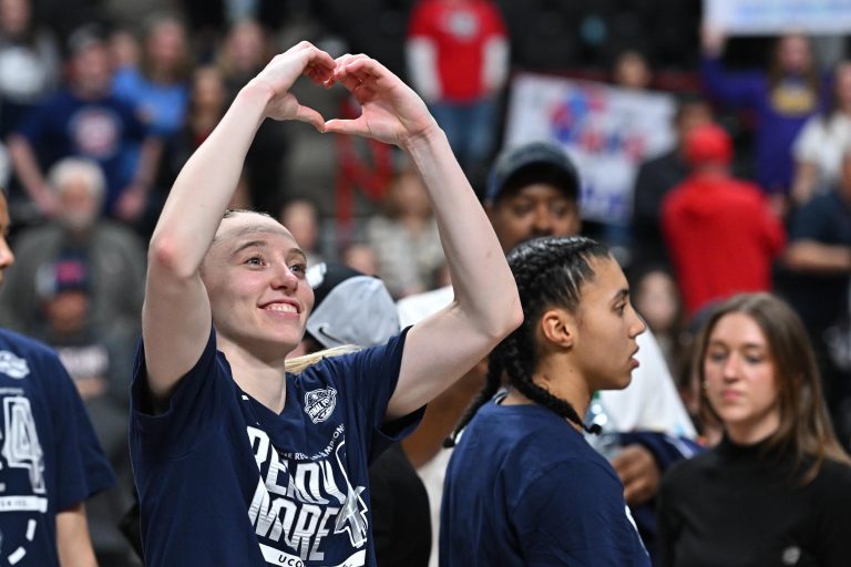 UConn Huskies guard Paige Bueckers (5) makes a heart symbol to the crowd after a Elite 8 NCAA Tournament basketball game against the USC Trojans at Spokane Arena.